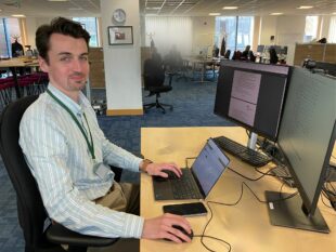 Daniel Robertson, Economist, sitting at his desk in front of his computer